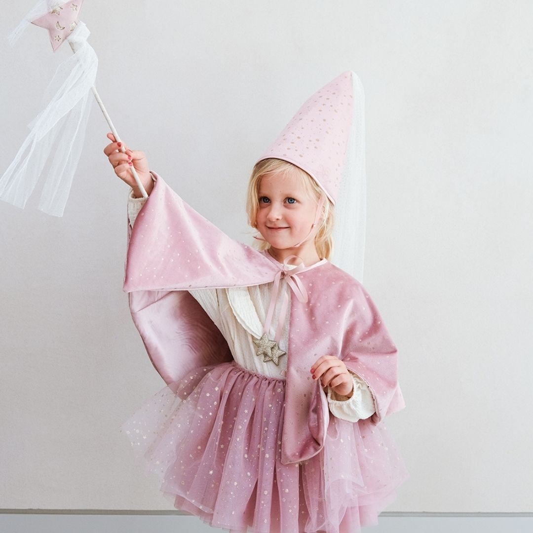 Pige med høj rosa hat og kort rosa kappe holder tryllestav med rosa stjerne på toppen og hvidt slør, perfekt udklædning som fe og prinsesse fra Mimi & Lula fås hos Nordic Simply