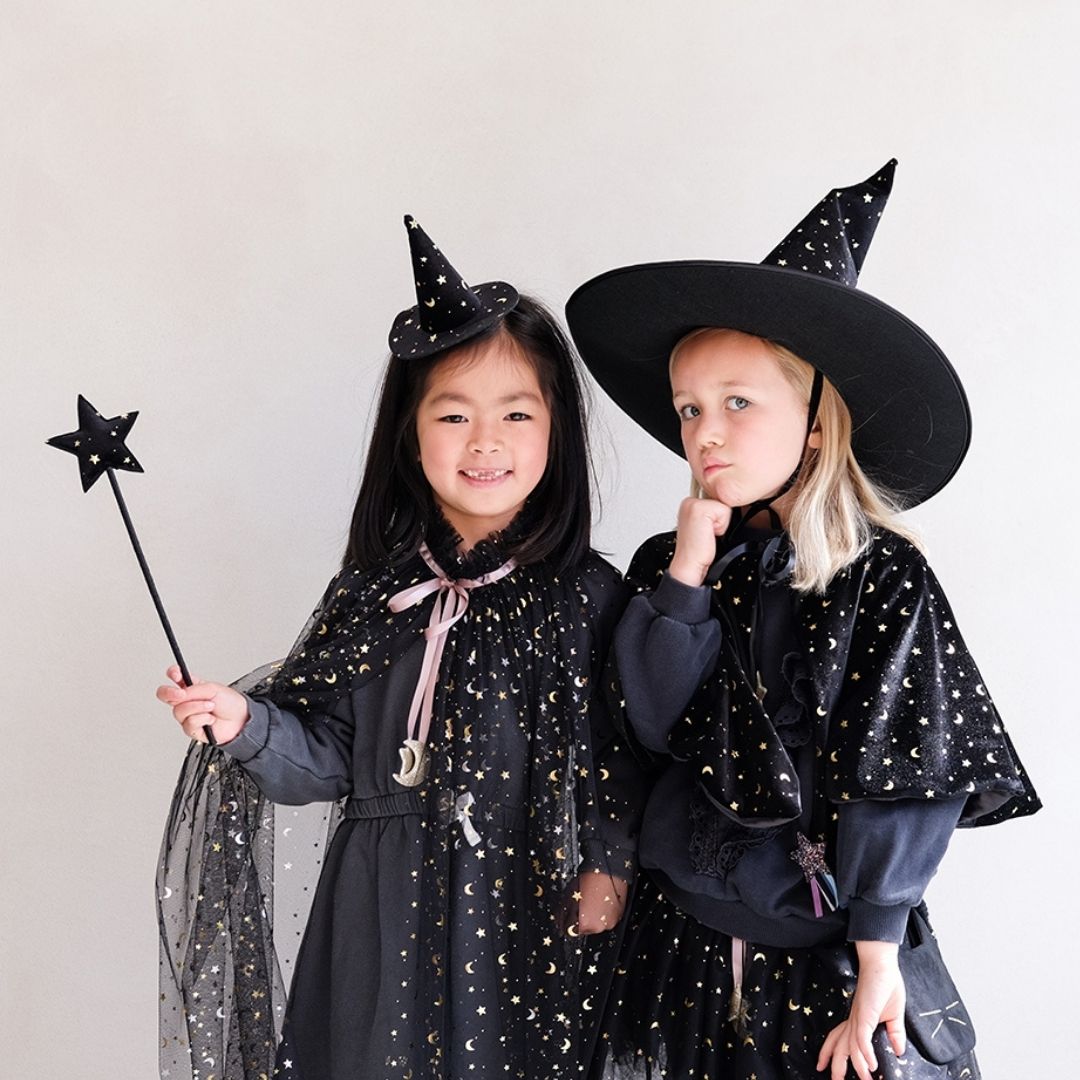 To piger udklædt som hekse, en holder sort tryllestav med stjerne på toppen i velour med små sølvstjerner, kommer på træpind beklædt med sort satin, fra Mimi & Lula fås hos Nordic Simply