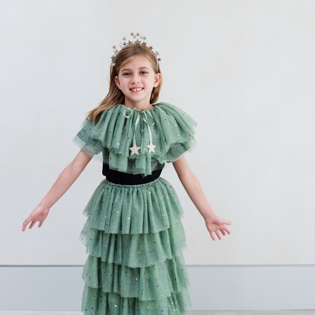 Pige med kort grøn kappe og langt grønt tylskort med flere lag og masser af stjerner, perfekt til udklædning, fra Mimi & Lula fås hos Nordic Simply