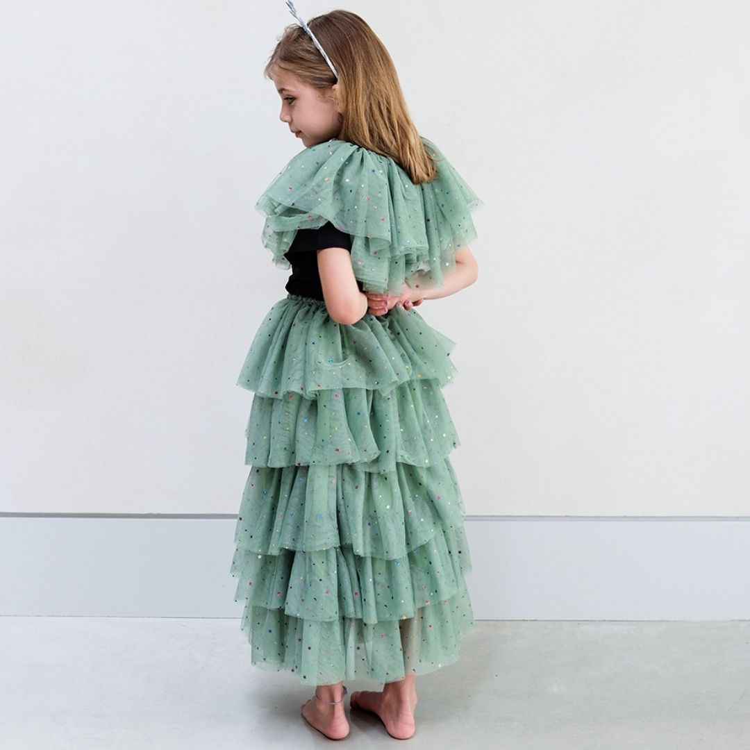 Pige set bagfra med kort grøn kappe og langt grønt tylskort med flere lag og masser af stjerner, perfekt til udklædning, fra Mimi & Lula fås hos Nordic Simply