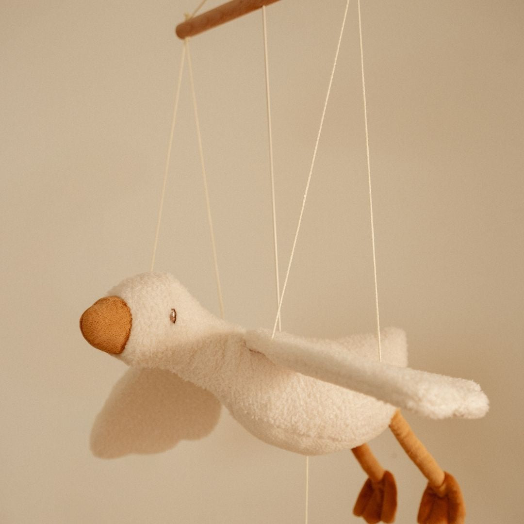 Mobile med hvid gås, der svæver gennem luften i et børneværelse, uro, der tilføjer ro og eventyr til værelset.