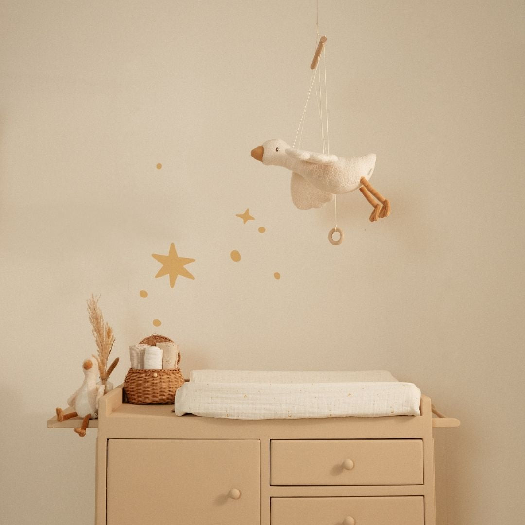 Uro med gås, der flyver, her set hængende over puslebord, skaber en drømmende atmosfære i børneværelset.