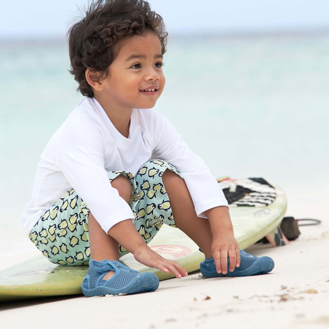 Dreng sidder på surfboard med hvid uv-bluse med lange ærmer str 24 måneder fra Lässig fås hos Nordic Simply