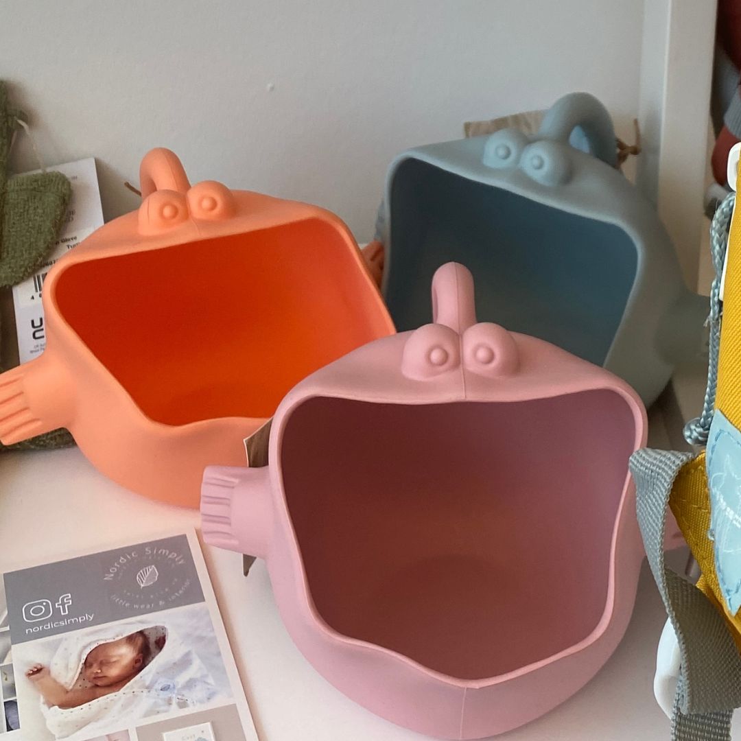 Tre vandkander formet som fisk i rosa, blå og koral med stor åben mund, står på hylde, fås hos Nordic Simply