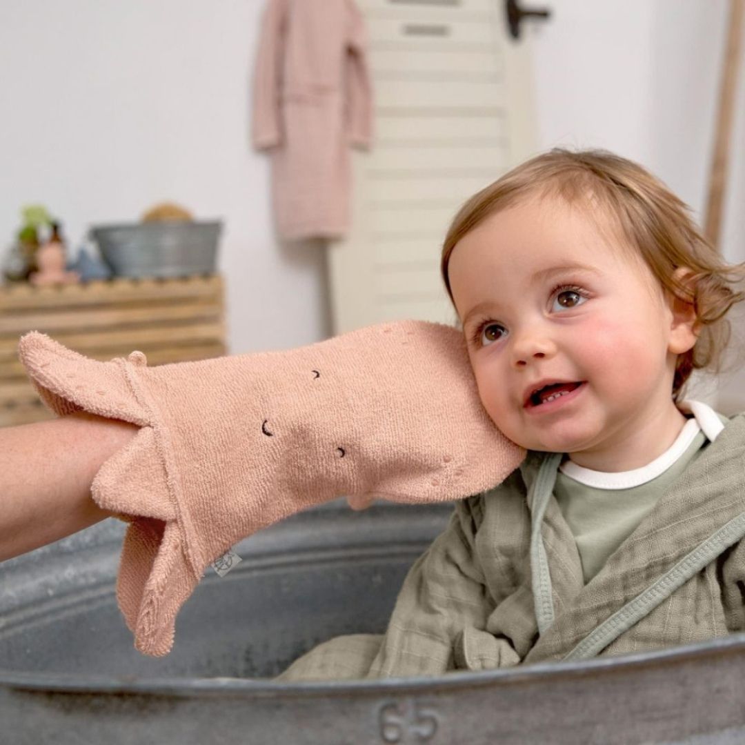 Barn bliver aet på kinden med rosa vaskehandske formet som en blæksprutte, 100% bomuld GOTS certificeret, fra Lässig fås hos Nordic Simply