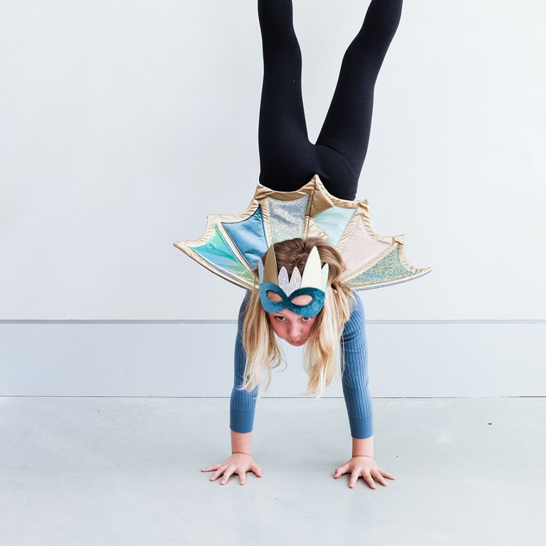Pige står på hænder med vinger på i pastelfarver med glitter og guld fra Mimi & Lula fås hos Nordic Simply