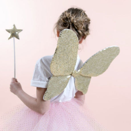 Pige set bagfra med guldtryllestav og vinger i guld og glitter, perfekt udklædning som sommerfugl til børn fra 3 år og op fra Mimi & Lula fås hos Nordic Simply