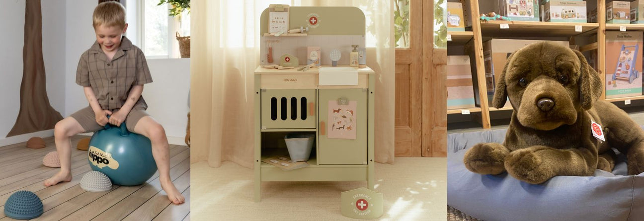 dreng på blå hoppebold i stue, dyrlæge station i træ i lyst rum, stor brun labrador bamsehund, julegaver til 4 årig hos Nordic Simply