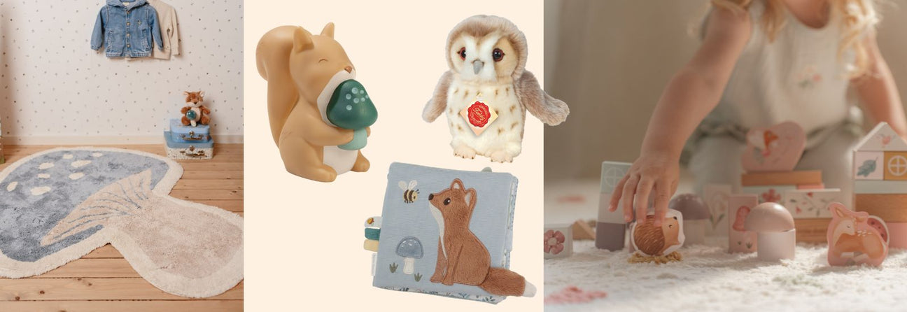 legetøj med tema fra skoven, legetæppe formet som blå svamp, lille egernlampe, blå aktivitetsbog med ræv, ugle bamse og barn der leger med rosa klodser med motiver fra skoven.