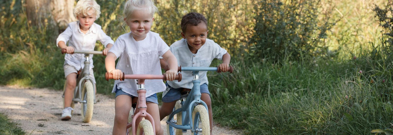 tre børn på tre løbecykler fra Little Dutch i mat rosa, oliven og blå hos nordicsimply