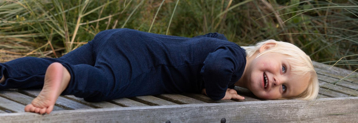 barn i blød mørkeblå dragt fra Joha, perfekt som natdragt. Find mere nattøj til baby og barn hos Nordic Simply
