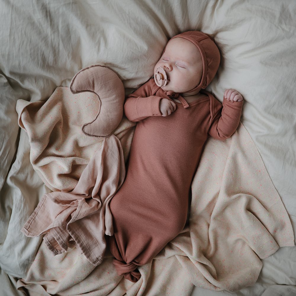 baby sover med rosa sut fra danske Frigg fairytale kollektion, str 1 passer baby fra 0-6 mdr. Med små hjertehuller