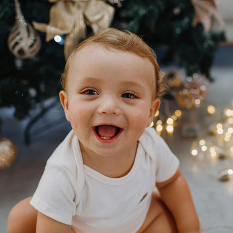 baby dreng ved juletræ klar til at modtage sin adventskalender fra Nordic Simply