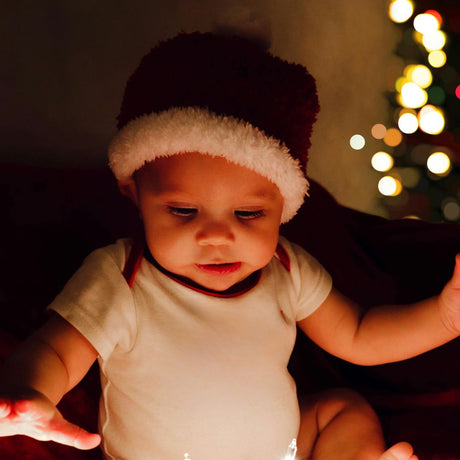 barn på 1-2 år med nissehue åbner gave til jul, find adventskalender til tumling dreng og pige hos Nordic Simply