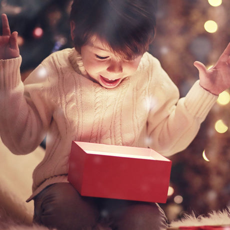 dreng på 6-9 år åbner gave til jul - som illustration til adventskalender til børn hos Nordic Simply