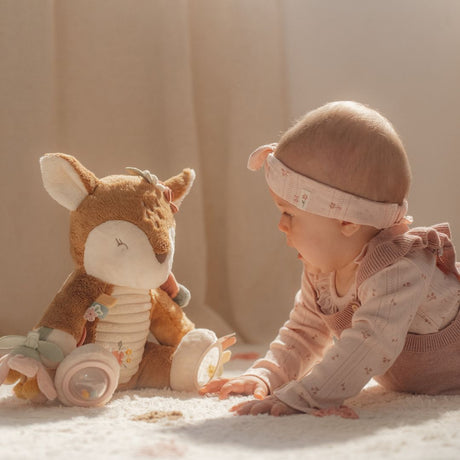 Pige ser på med aktivitetsbamse rådyr fra Little Dutch med sjove teksturer og lyde, fås hos Nordic Simply.