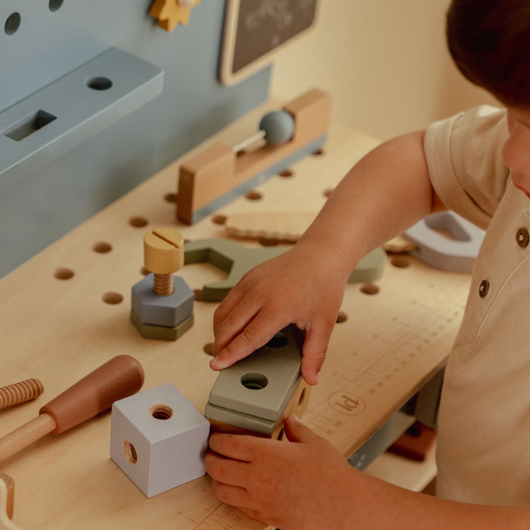 Barn leger ved stor blå arbejdsbænk i træ med masser af værktøj fra Little Dutch, perfekt til rolle-og fantasileg for din lille håndværker, fås hos Nordic Simply 