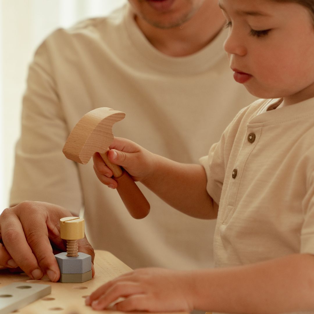 Barn slår med hammer, som følger med arbejdsbænk i træ fra Little Dutch, perfekt til rolle-og fantasileg for din lille håndværker, fås hos Nordic Simply 
