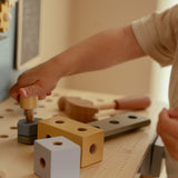 Barn leger ved stor blå arbejdsbænk i træ med masser af værktøj fra Little Dutch, perfekt til rolle-og fantasileg for din lille håndværker, fås hos Nordic Simply 