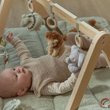 Baby under aktivitetsstativ med safaridyr, babygym i træ med grønne ben og tre dyr at udforske: elefant, løve og krokodille. Fra Little Dutch.