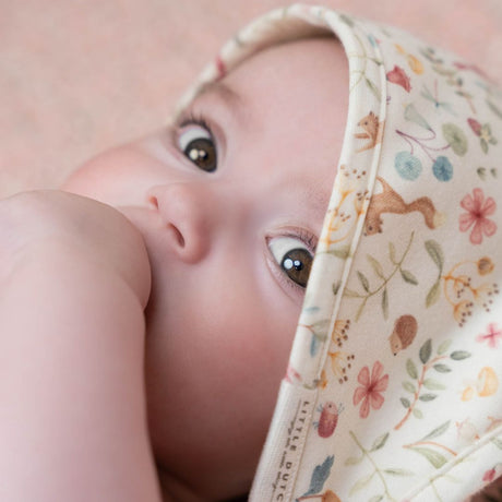 Badehåndklæde hvid i økologisk frotté, her baby iført hætte med skovmotiv.