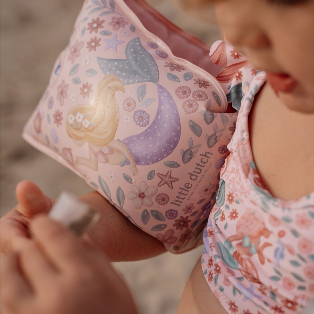 Rosa svømmevinger med havfrue motiver fra little Dutch, her set tæt på, på armen af et barn.