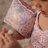 Rosa svømmevinger med havfrue motiver fra little Dutch, her set tæt på, på armen af et barn.