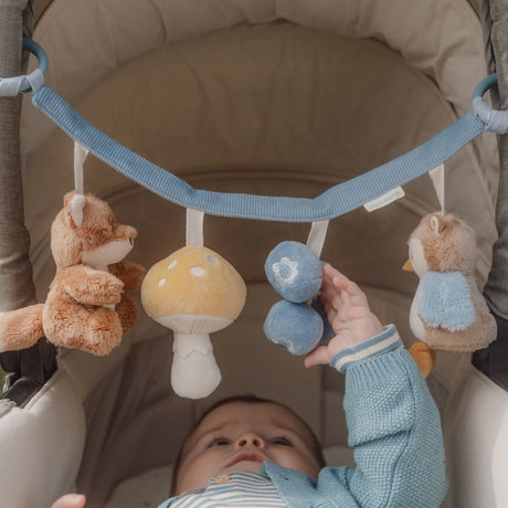 Baby i barnevogn rører ved barnevognskæde i blå med ræv og søde dyr fra skoven.