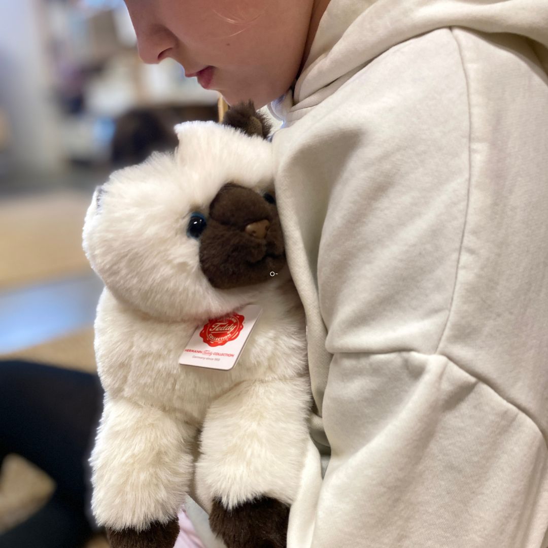 barn sidder med hvid og sort Birma kattebamse med store blå øjne, fra Teddy Hermann, hos Nordic Simply