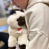 barn sidder med hvid og sort Birma kattebamse med store blå øjne, fra Teddy Hermann, hos Nordic Simply