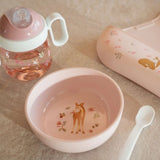 rosa børneskål med motiv af rådyr, set på bord sammen med ske, tudkop og hagesmæk i samme serie fra Mepal x Little Dutch.
