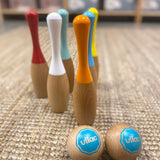 6 kegler fra bowlingsæt i træ i flotte farver, står på lyst tæppe med to kugler i træ foran. Flot spil til børn fra 5 år og op i høj kvalitet.