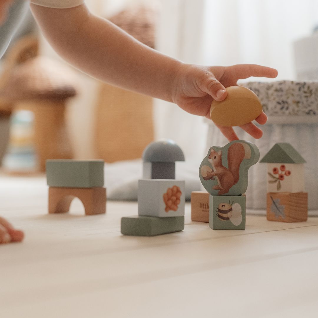 Barn bygger med blå træklodser og motiver af skovens dyr, sjov leg med Little Dutch byggeklodser.