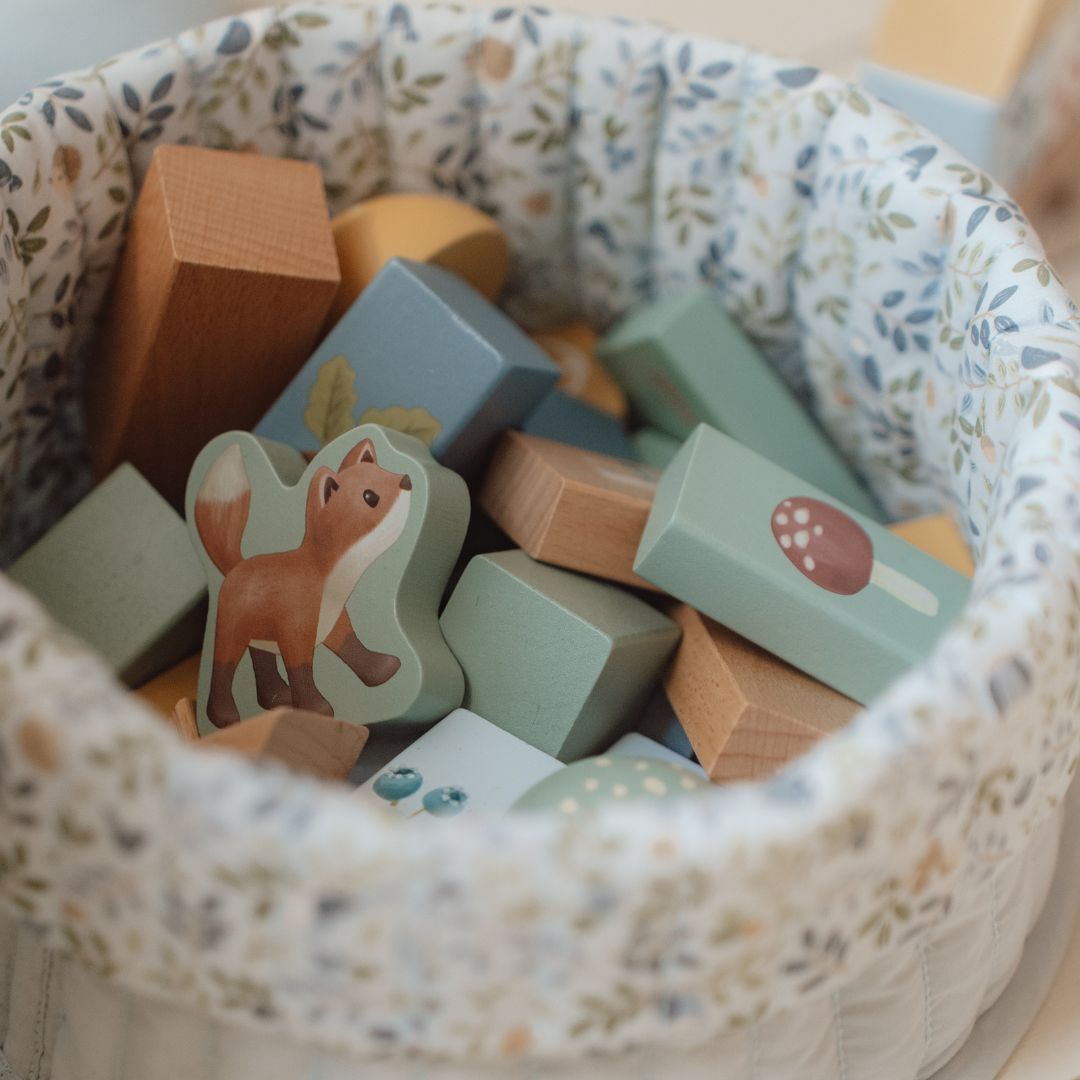 Farverigt sæt af FSC-certificerede byggeklodser med skovtema og dyr, i en praktisk kurv.