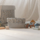 Farverige byggeklodser og opbevaringskurve i lyse, bløde farver set i stue.