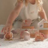 Barn leger med 50 rosa træklodser dekoreret med feer og dyr fra Little Dutch.