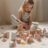 Barn leger med rosa byggeklodser fra Little Dutch, dekoreret med feer og dyr, i hyggelig stue.