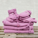Rosa cardigan i blød merinould fra Joha, her set i stak sammen med futter og vanter i samme farve, perfekt til babys første køreture.