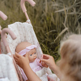 Dukke Lily sidder i klapvogn mens hun får kærlighed og omsorg.