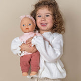 Dukke Lily med udstyr, 36 cm, trygt i armene på en glad lille pige.