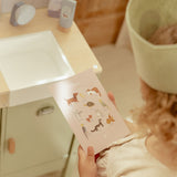 Barn leger med dyrlægeklinik fra Little Dutch og viser kort i træ med søde kæledyr.