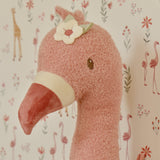 pink flamingohoved med hvid blomst hænger på væg med matchende safari tapet i børneværelse. 