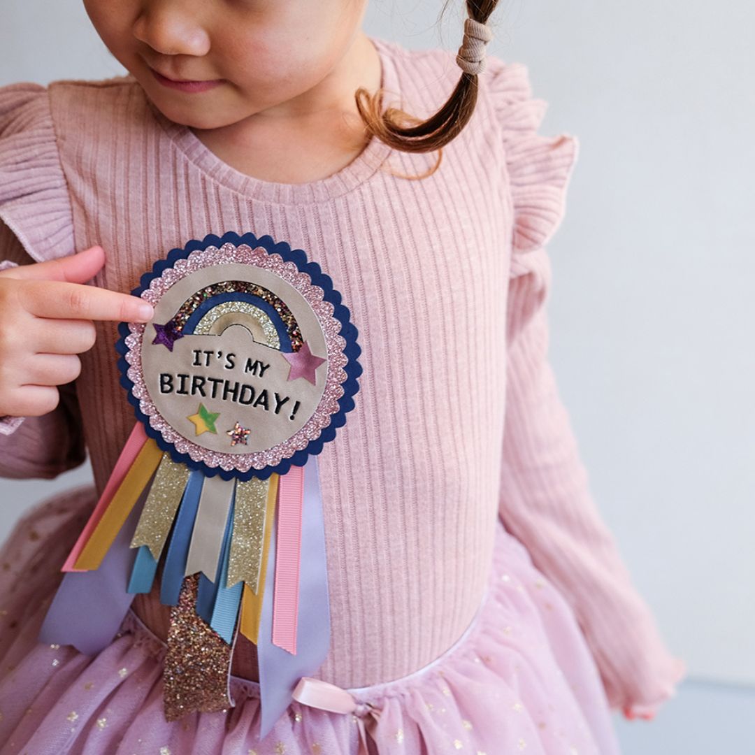Pige med "it's my birthday" badge, en festlig fødselsdagsbadge til fejring af fødselsdag for børn fra 3 år og op