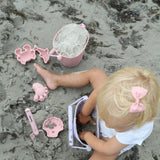 pige leger med rosa sandforme i silikone på strand, perfekt til små hænder fra 1 år og op, høj kvalitet fra Scrunch