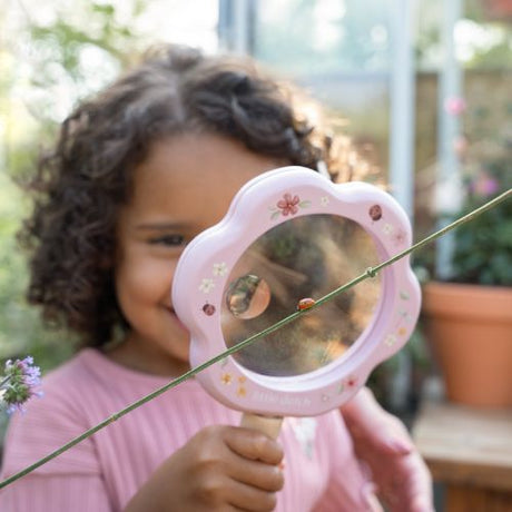 Barn holder et stort rosa forstørrelsesglas fra Little Dutch, og er på opdagelse i naturen med et smil!