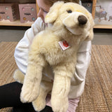 barn sidder med stor lys Golden Retriever bamse, på lyst gulvtæppe hos danske Nordic Simply - en blød og krammevenlig bamse til leg