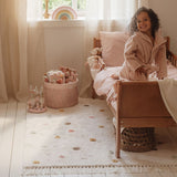 Beige gulvtæppe med prikker, økologisk bomuld i hyggeligt børneværelse med glad pige