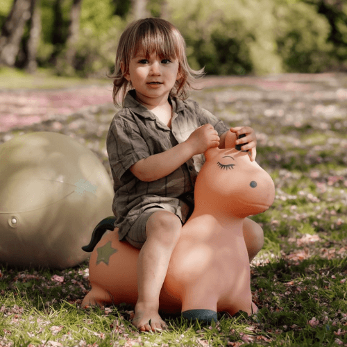 pige på rosa enhjørning hoppedyr udendørs fra find that hippo hos nordicsimply