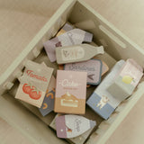 indkøbsvogn i træ set oppefra med farverige legetøjsvarer som tomater, kageblanding og sæbe til rolleleg