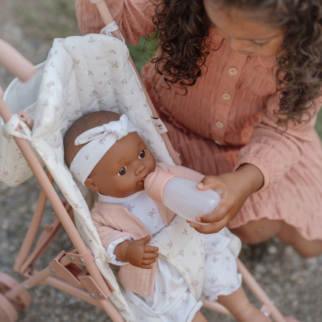 Barn sidder ved dukke i smuk dukke klapvogn fra Little Dutch, fås hos Nordic Simply